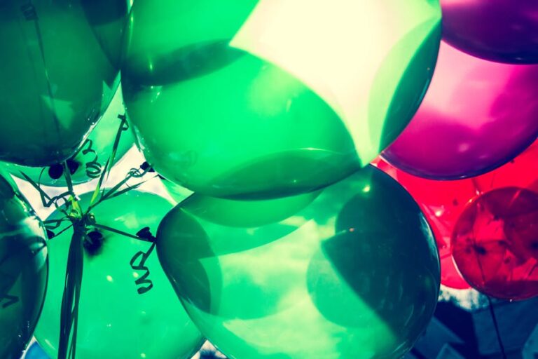 Colorful green and pink balloons captured in close-up for a festive celebration.